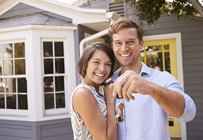 happy family in front of their new home